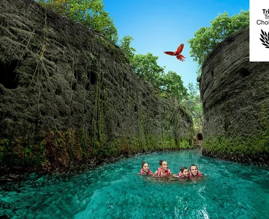 Nageurs dans une rivière turquoise entre des parois rocheuses à Xcaret