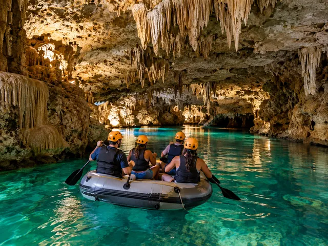 Quatre personnes en casque pagayant sur un radeau dans une grotte éclairée